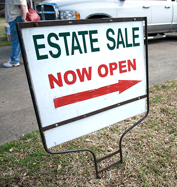 an estate sale yard sign guides customers to a local neighborhood sale