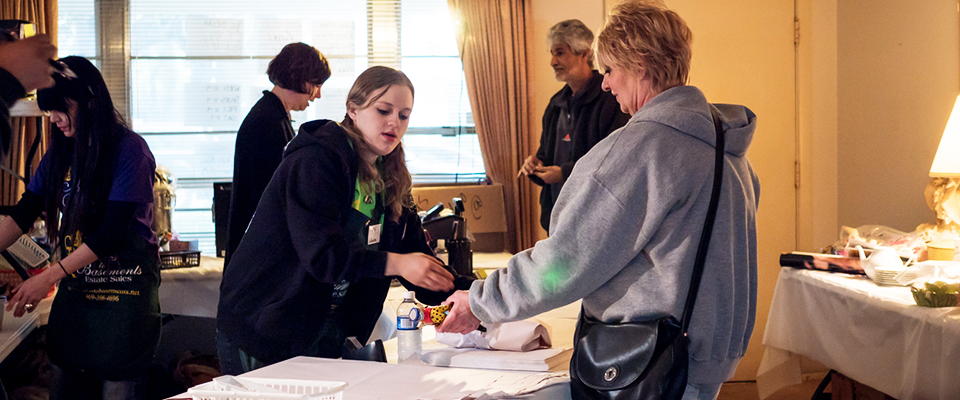 clerk takes payment for items purchased at an estate sale