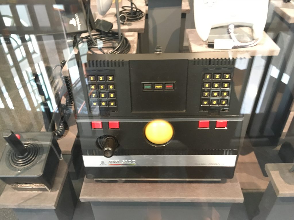 black video game console with yellow ball in center