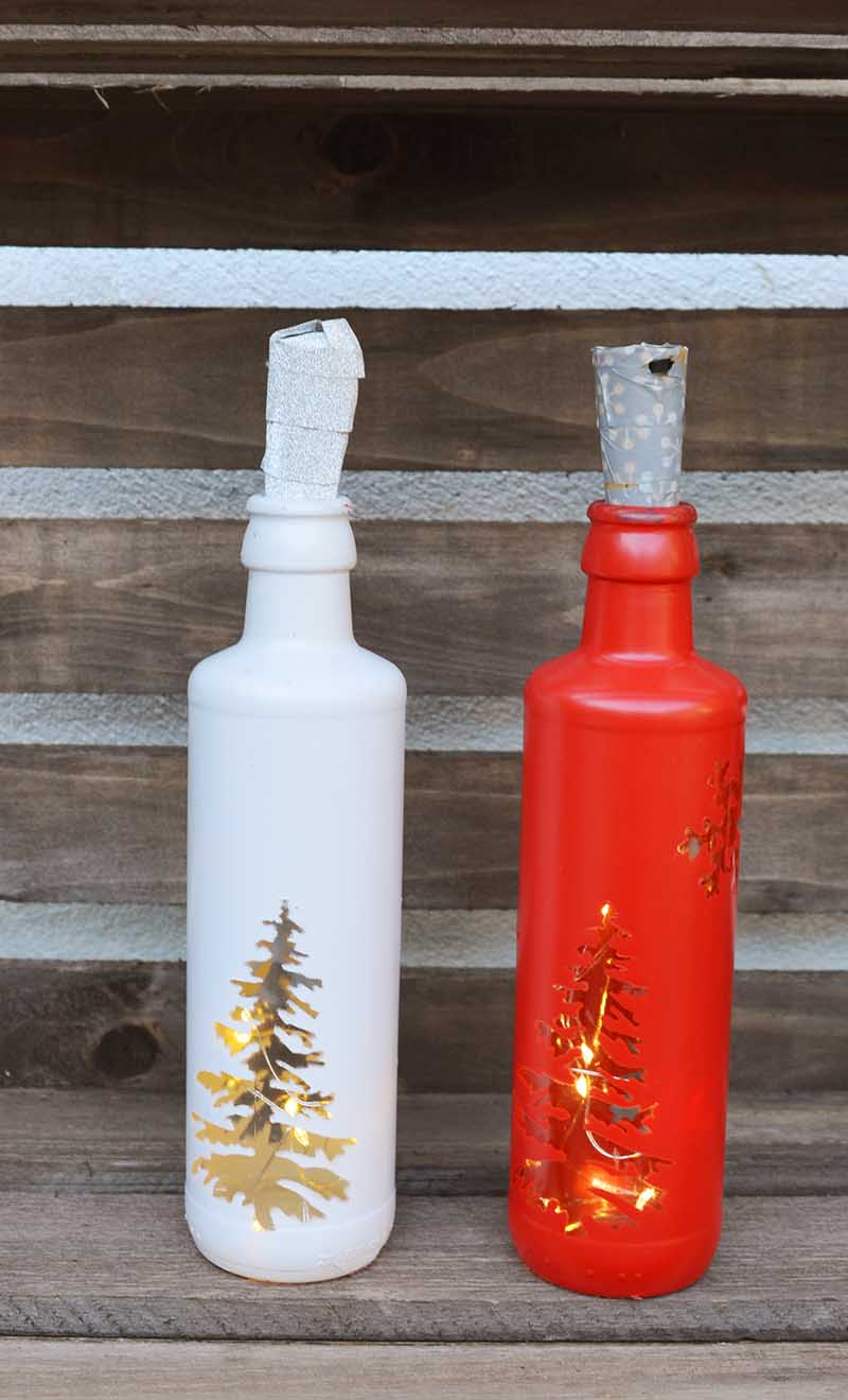 A painted white and red bottle with Christmas tree windows.