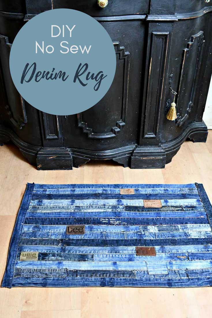 A rug made of denim wasitbands on a wooden floor next to a black chest.