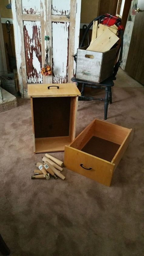 Two empty brown drawers and several short table legs sit on a brown carpet.