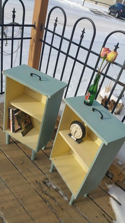 Two yellow and blue side tables upcycled from drawers sit on a porch. 