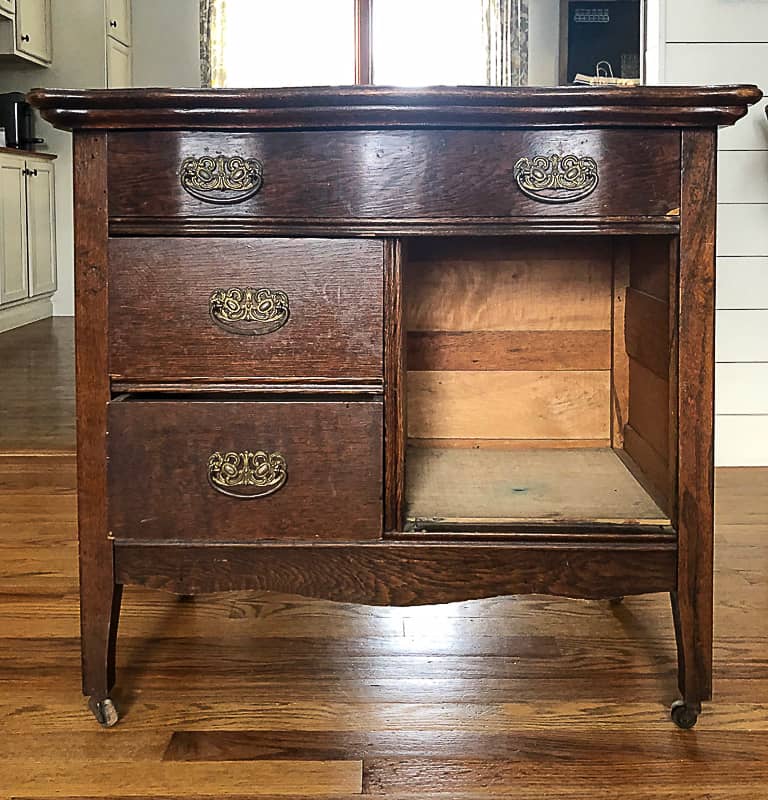 A wooden three-drawer dresser sits on a wooden floor.