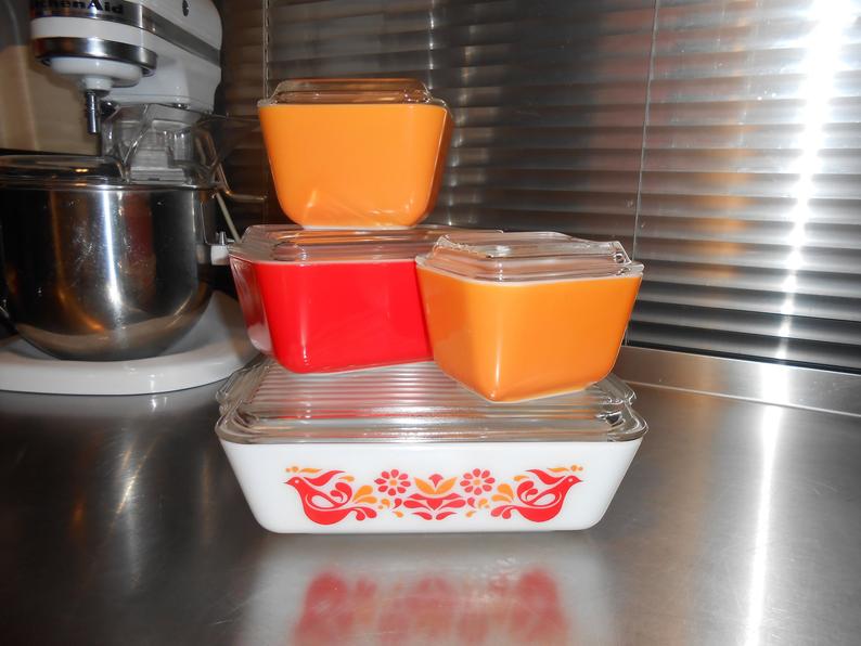 Four glass Pyrex dishes in orange and red.
