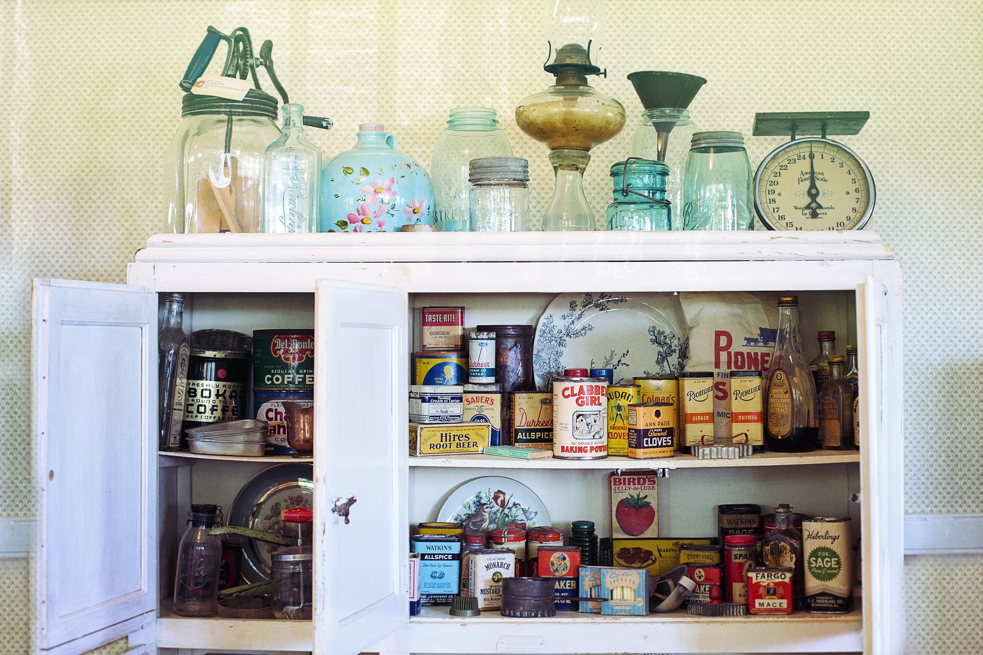 A cabinet with lots of old jars and cans.