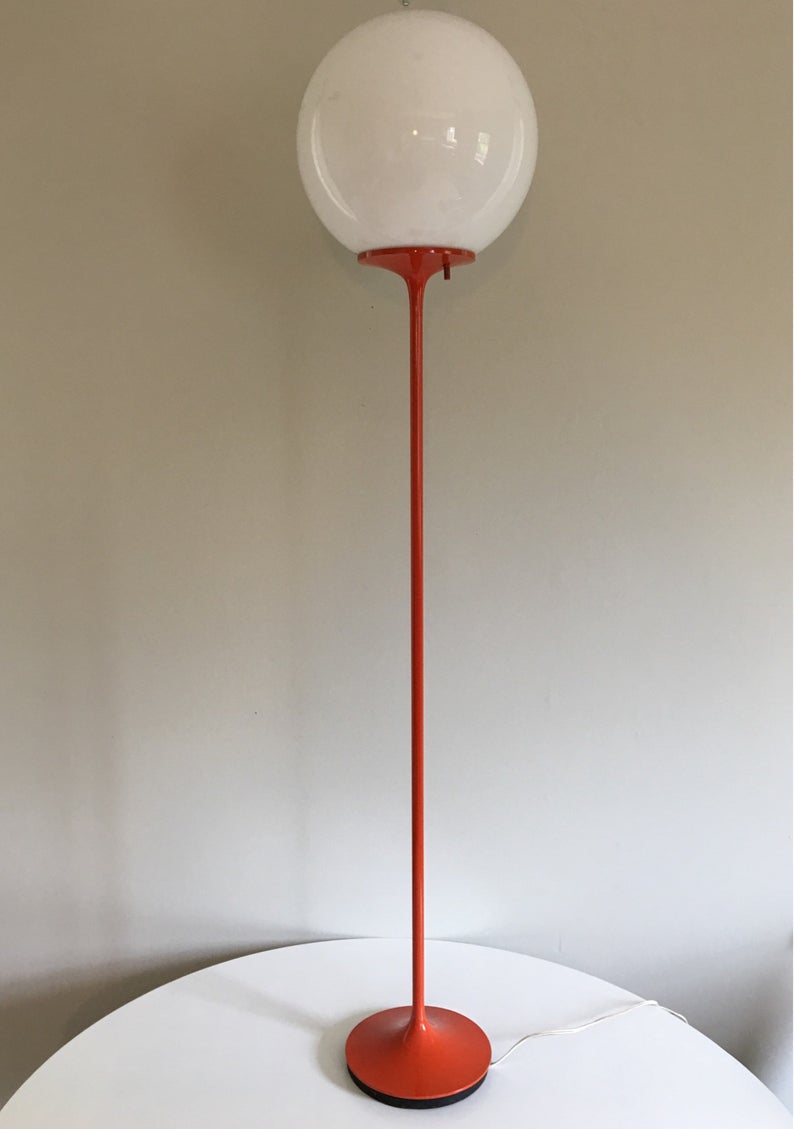 Tall orange lamp with white shade.